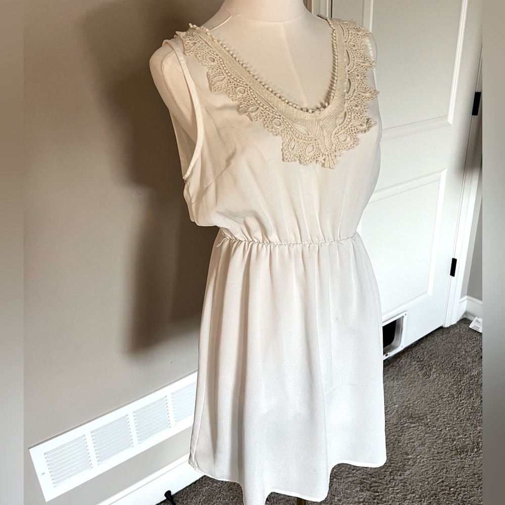 Medium women’s white dress with cream embroidery around neck.